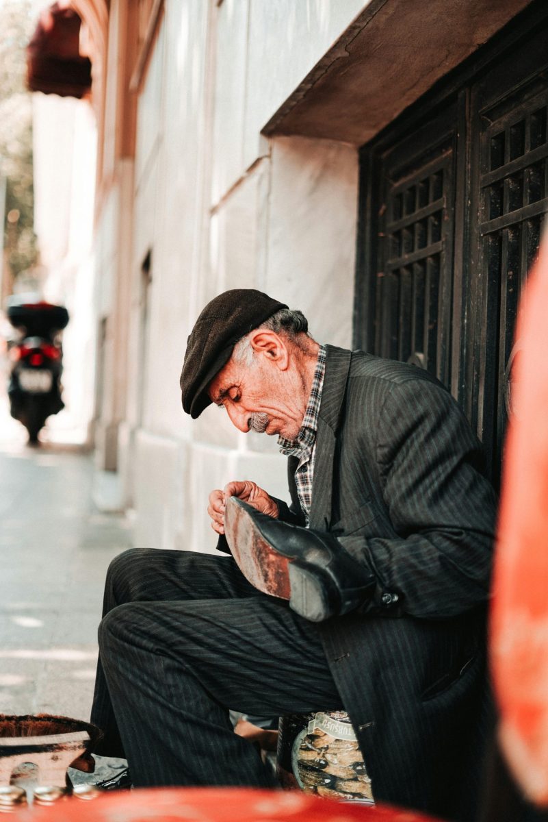 An elderly cobbler repairing a shoe