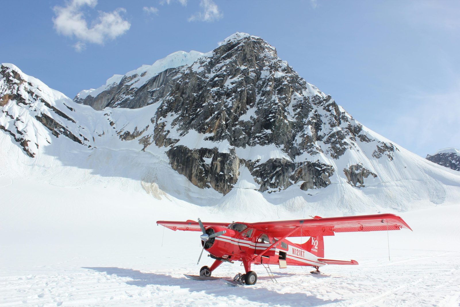 Vibrant red plane on the snowy terrain of Denali National Park, Alaska.