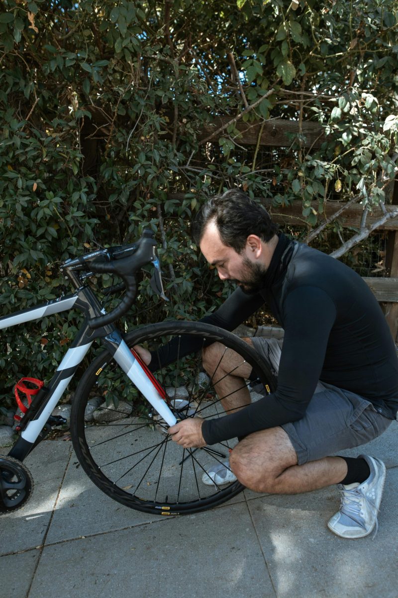 A man kneels to repair a bicycle tire.