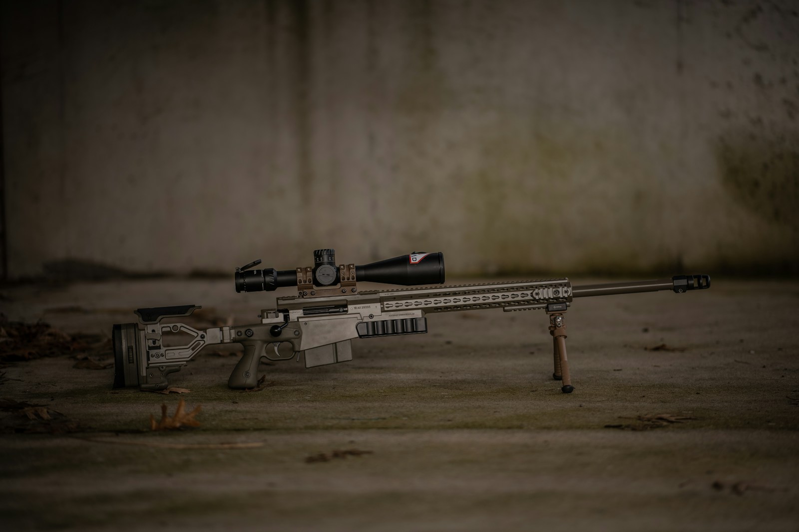 A rifle laying on the ground with a scope