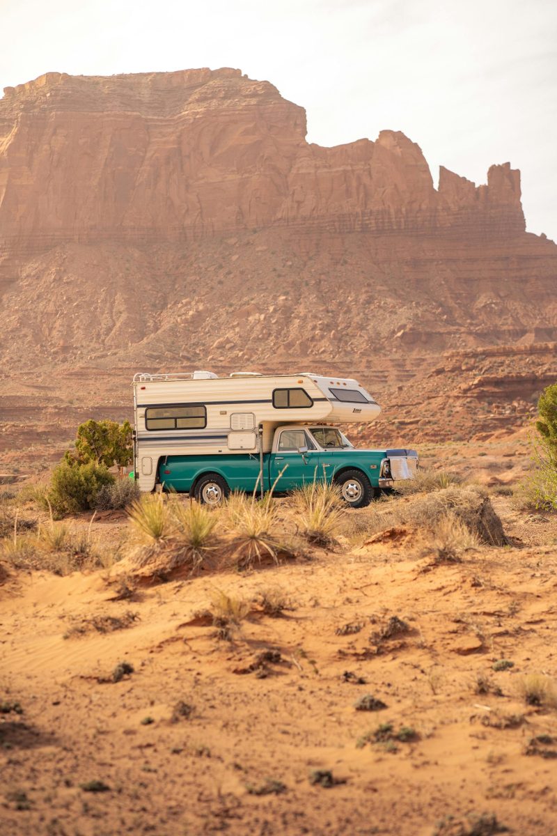 A camper van parked amidst Monument Valley's stunning desert scenery in Arizona.