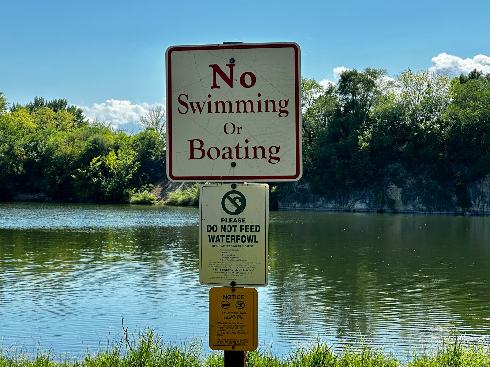 No swimming or boating sign next to a lake