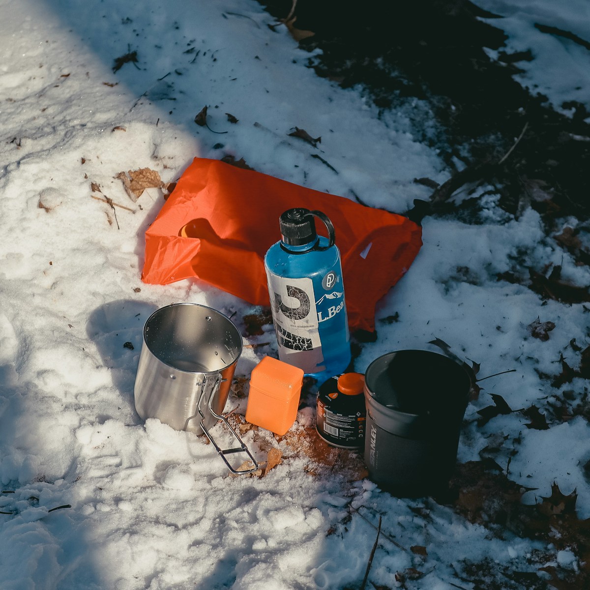 A bottle of water sitting on top of a snow covered ground
