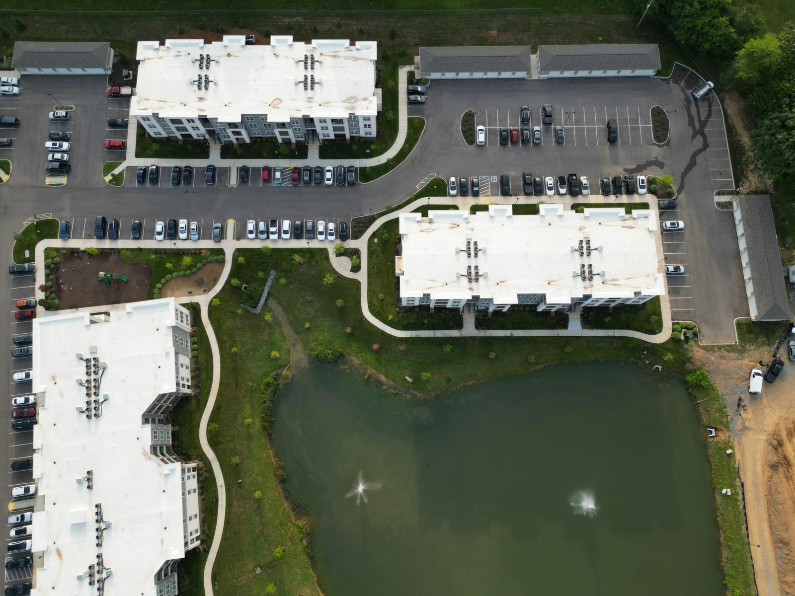 Drone view of apartment buildings, parking lots.