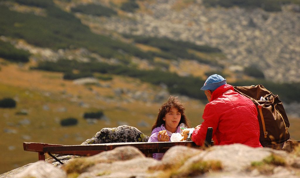Hikers Eating while Hiking on Mountain
