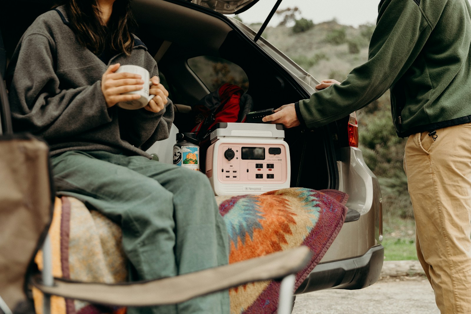 Acouple of people standing next to a car