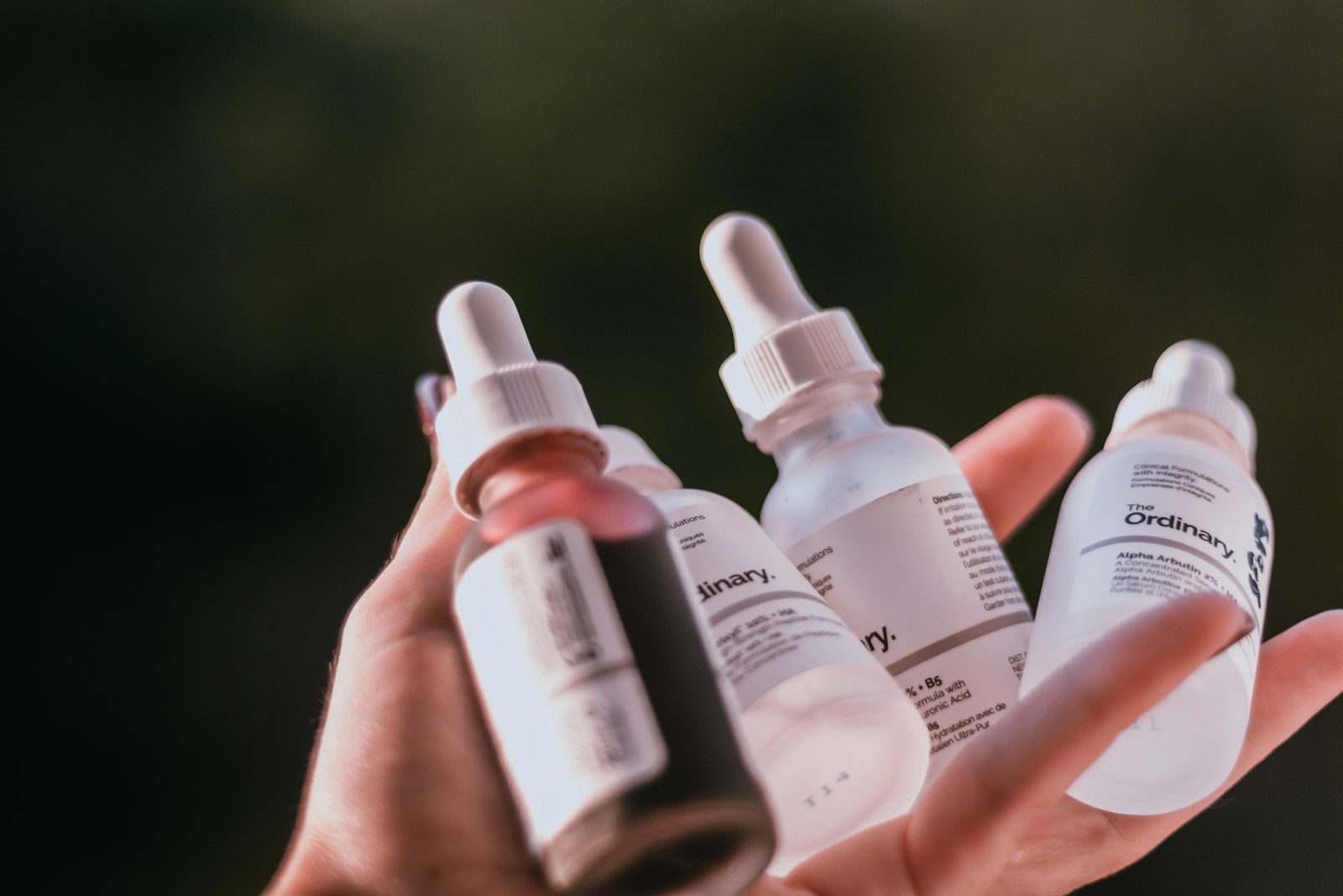 person holding white and black medicine bottles