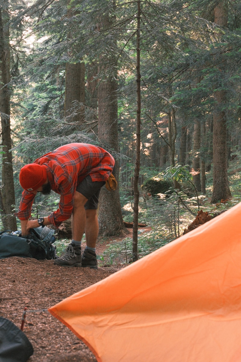 Man making his backpack in a forest.