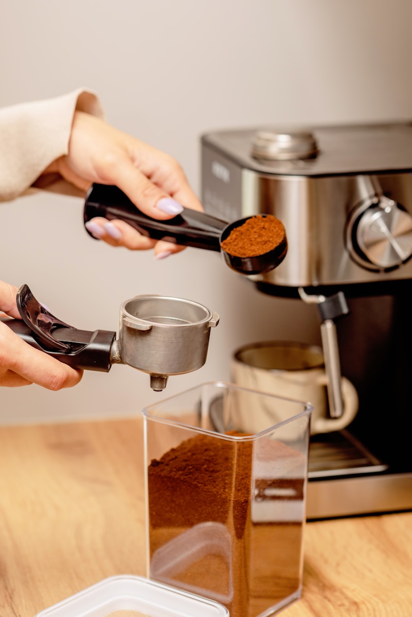 A person pouring a cup of coffee from a coffee maker.