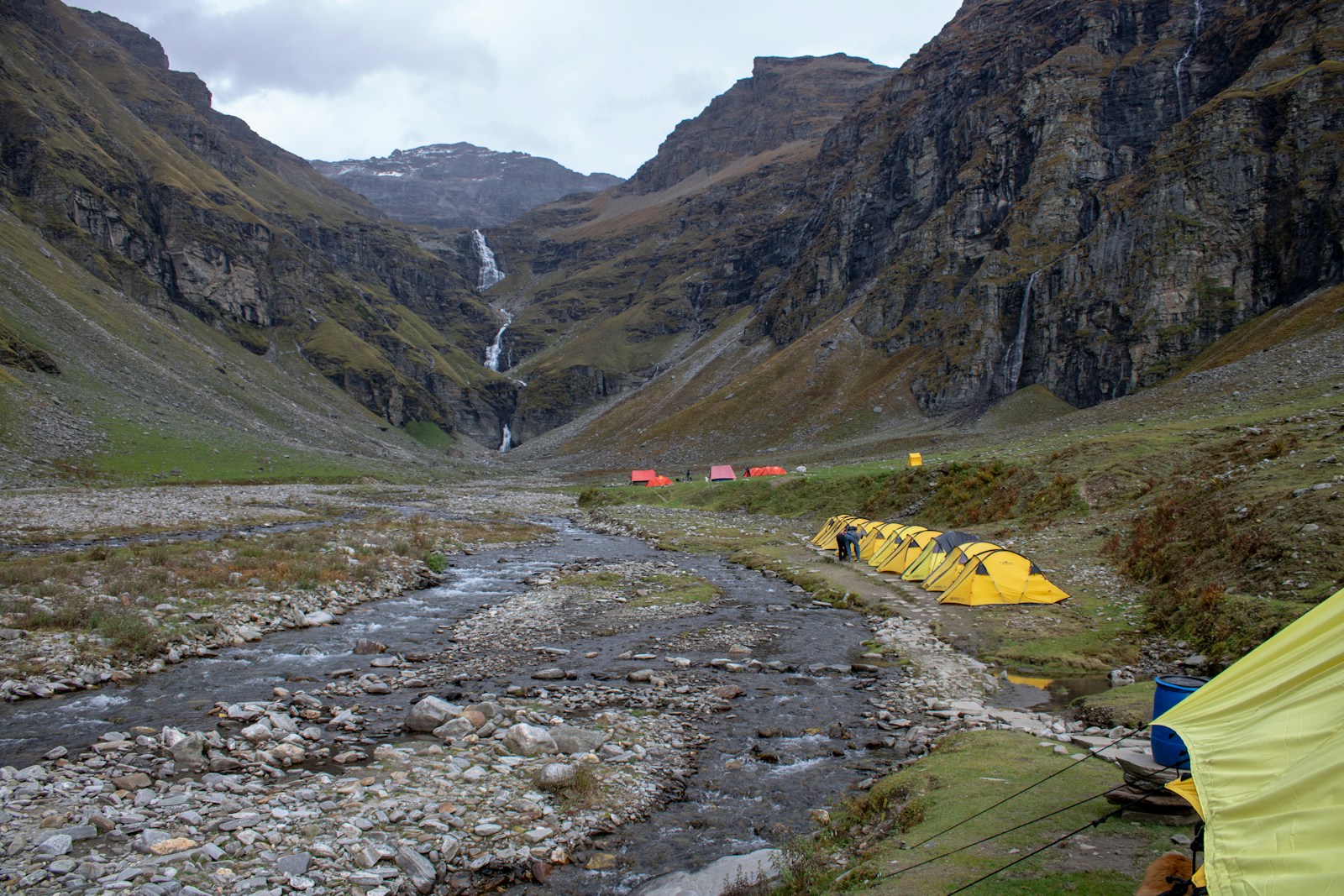 A couple of tents sitting on top of a lush green hillside