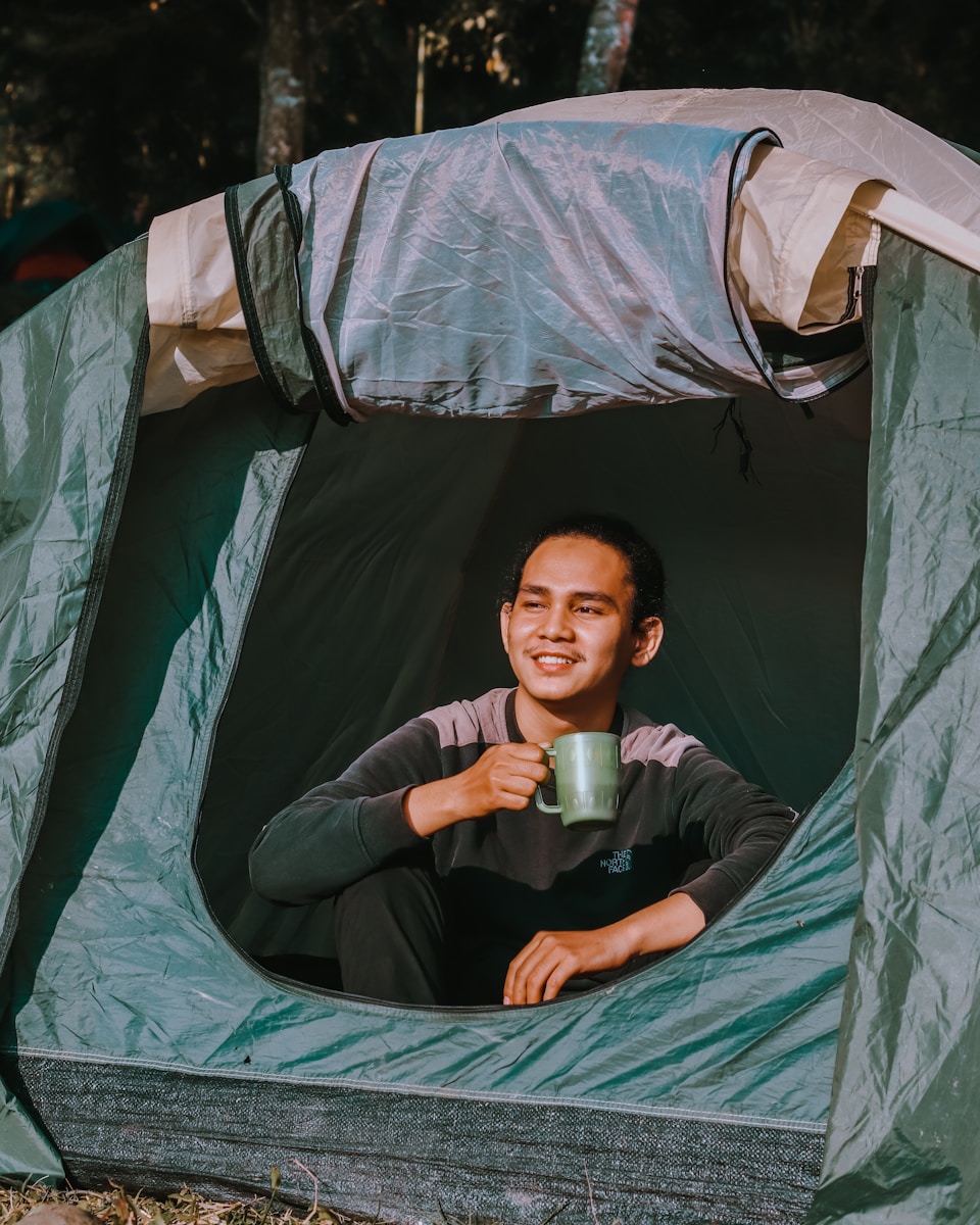 A Person Drinking Coffee while on Camping