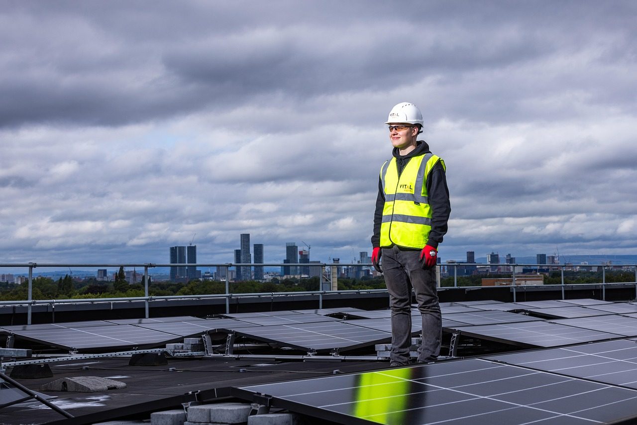 A Man Standing on a Rooftop surrounded by Solar Panel