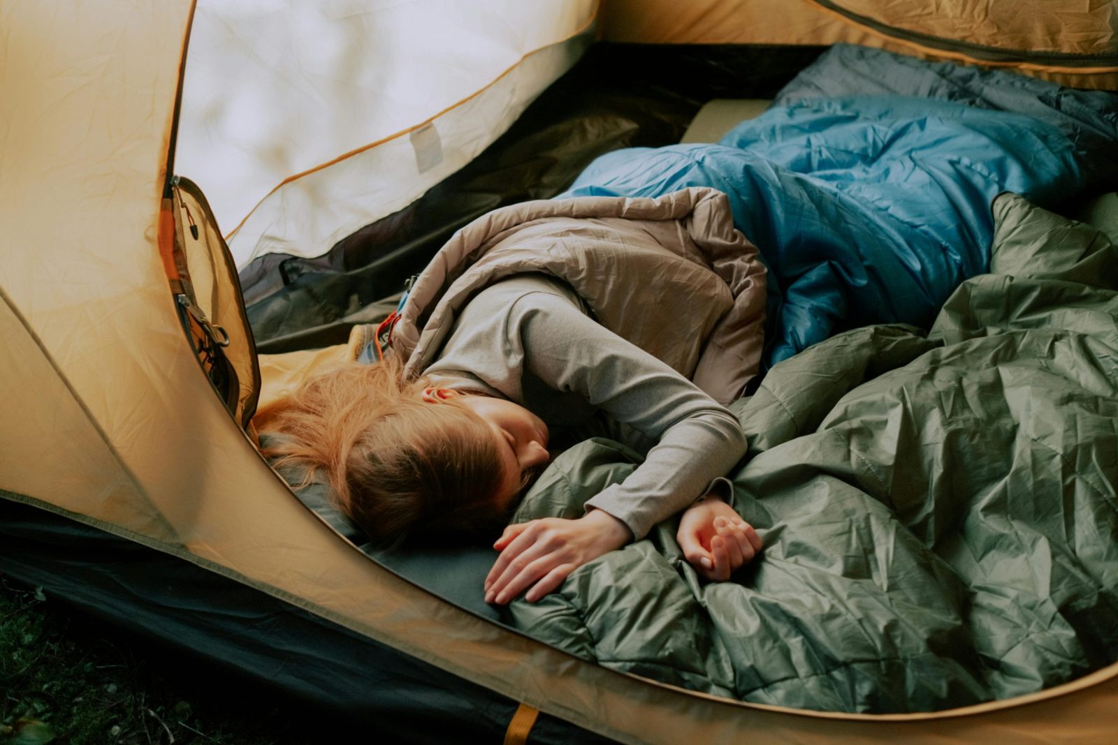 A serene scene of a woman sleeping comfortably in a tent.