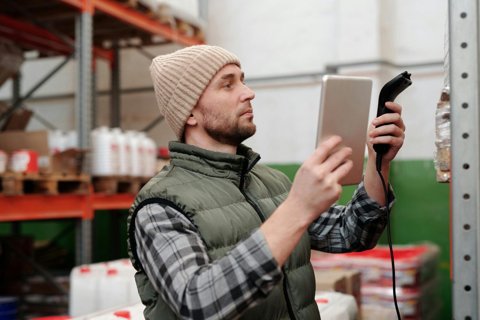 Man in beanie and vest using a scanner to check power.