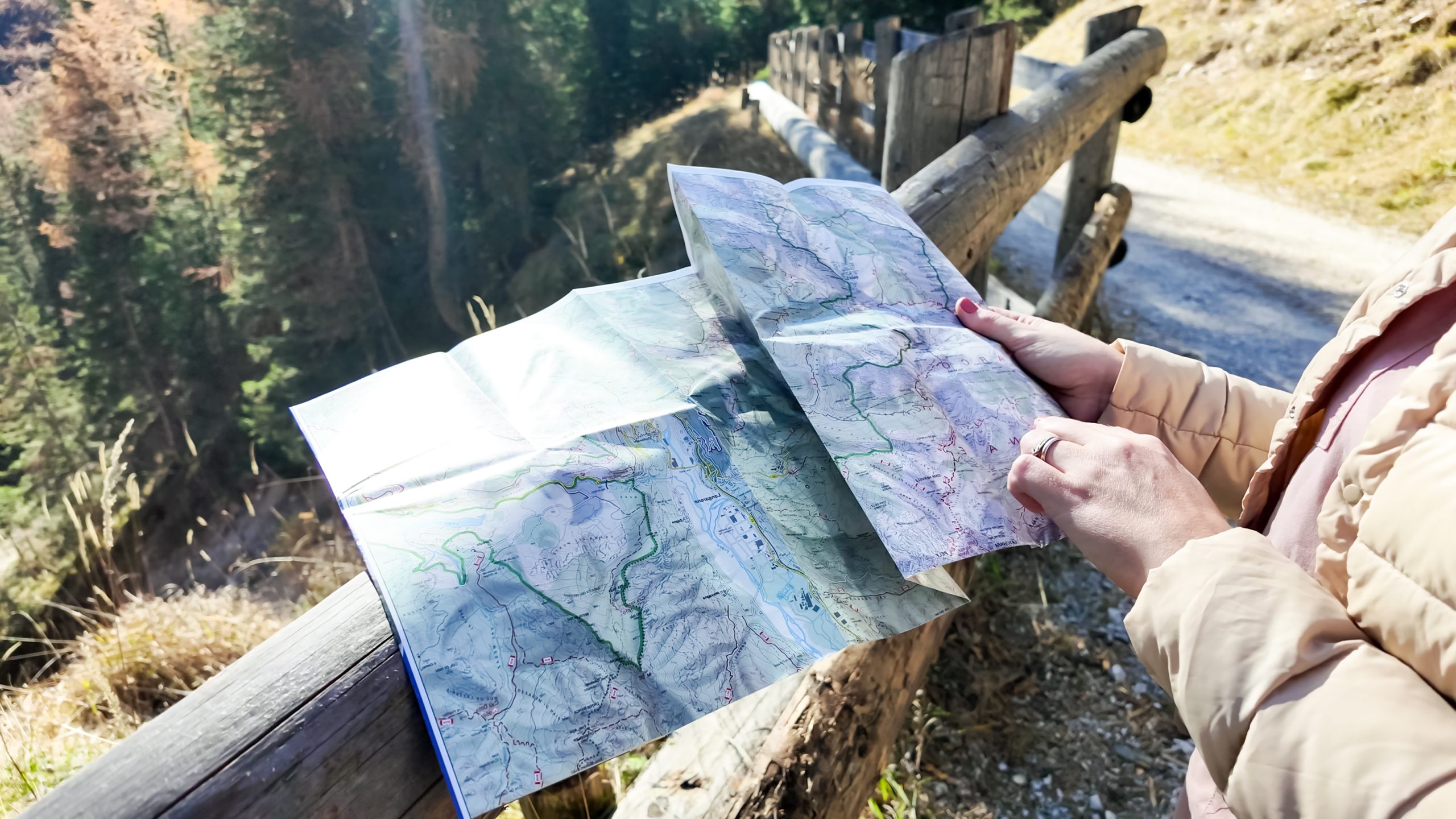 A person Holding Map and A Compass