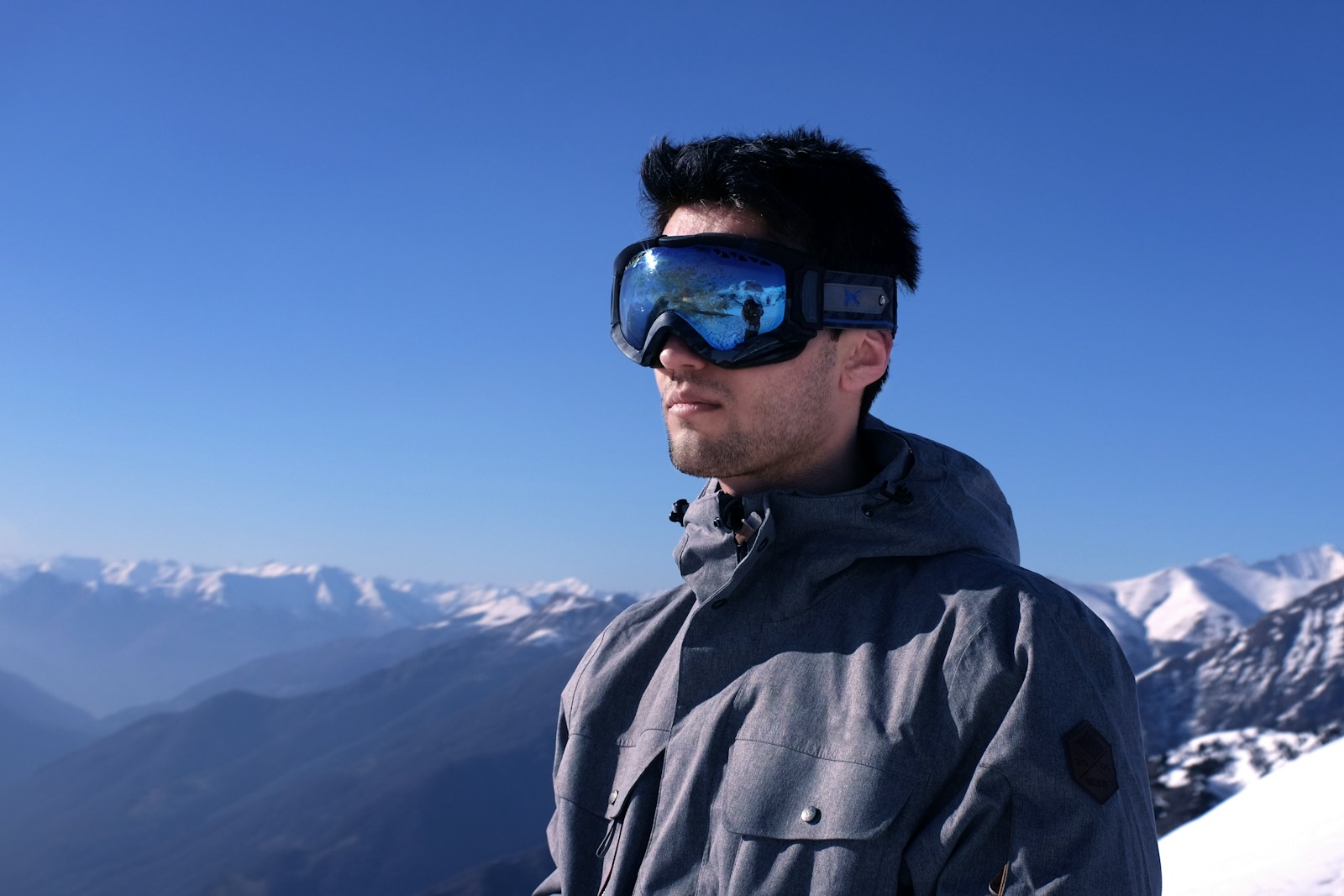 A man in gray jacket wearing black sunglasses