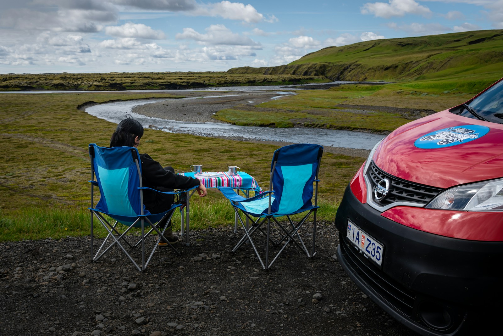 taiki-ishikawa-w6EMxsk8CDA-unsplash A person sitting in a chair next to a red car