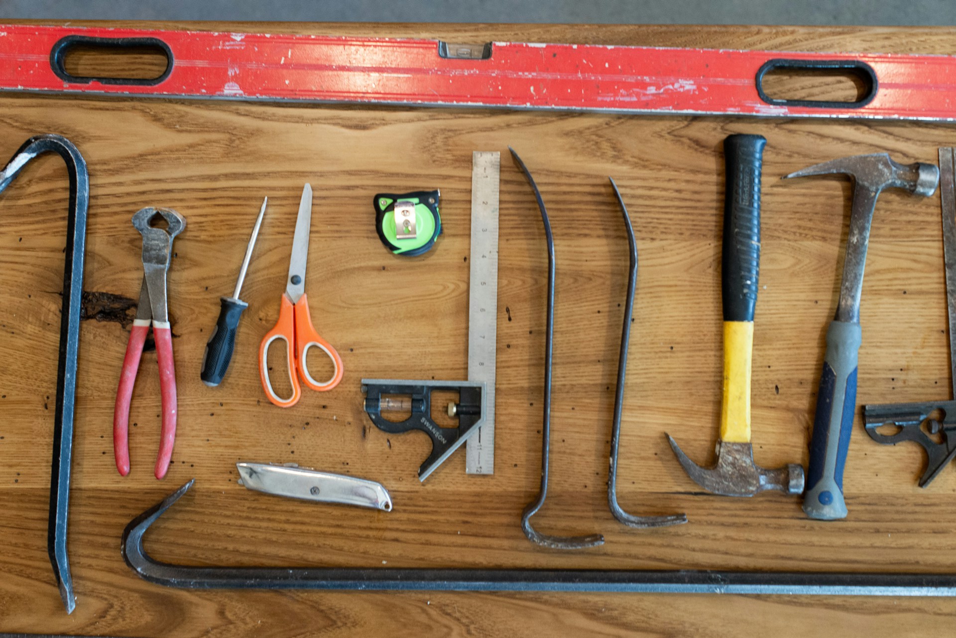 Assorted hand tools on brown wooden table