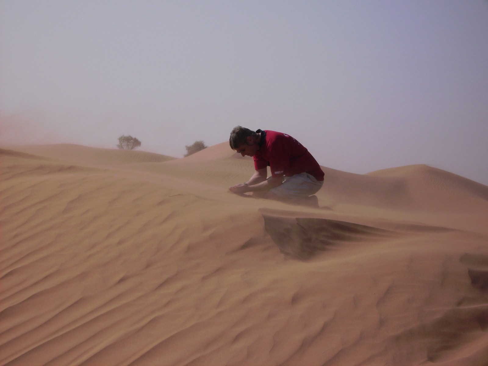a man kneeling down in the middle of a desert