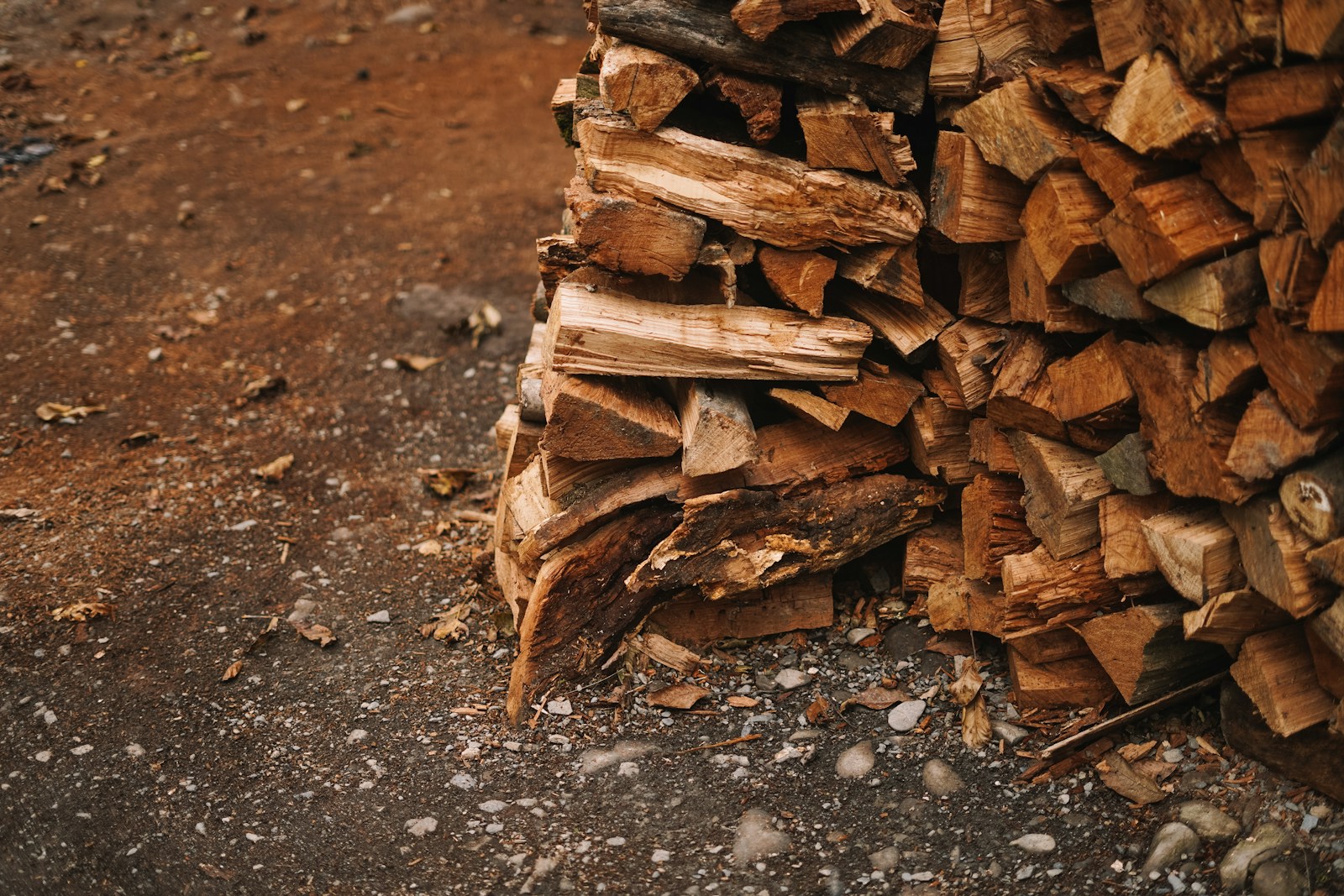 a pile of wood sitting on top of a dirt ground
