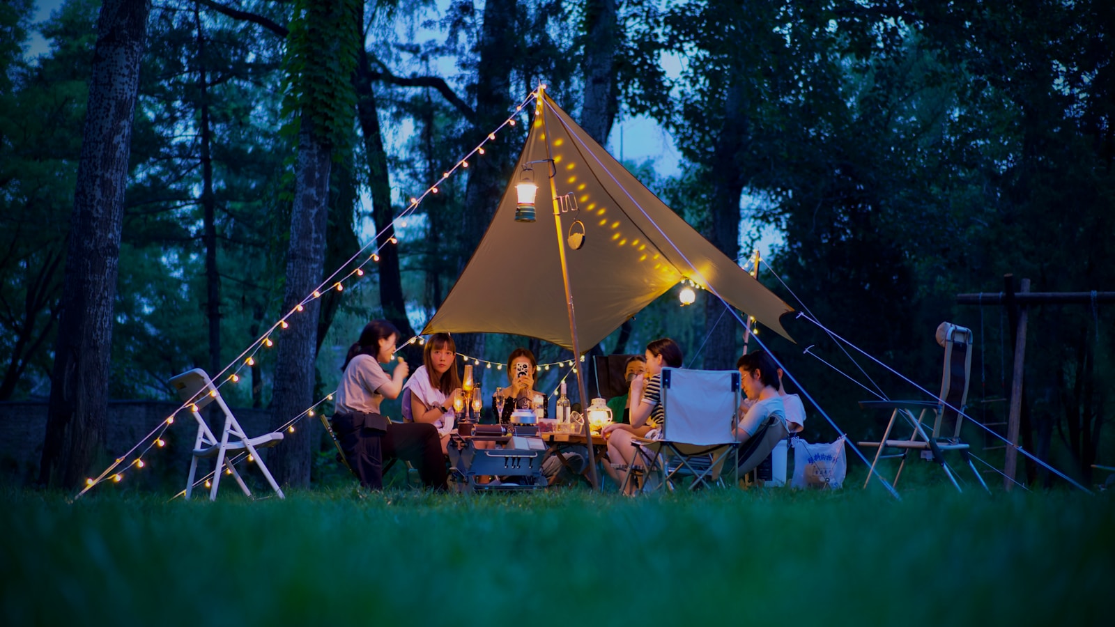a group of people sitting around a dining table in campsite