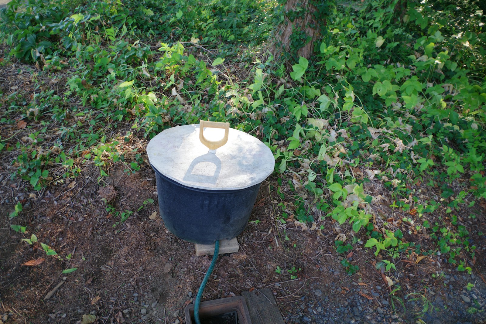 A metal bucket sitting on top of a dirt field