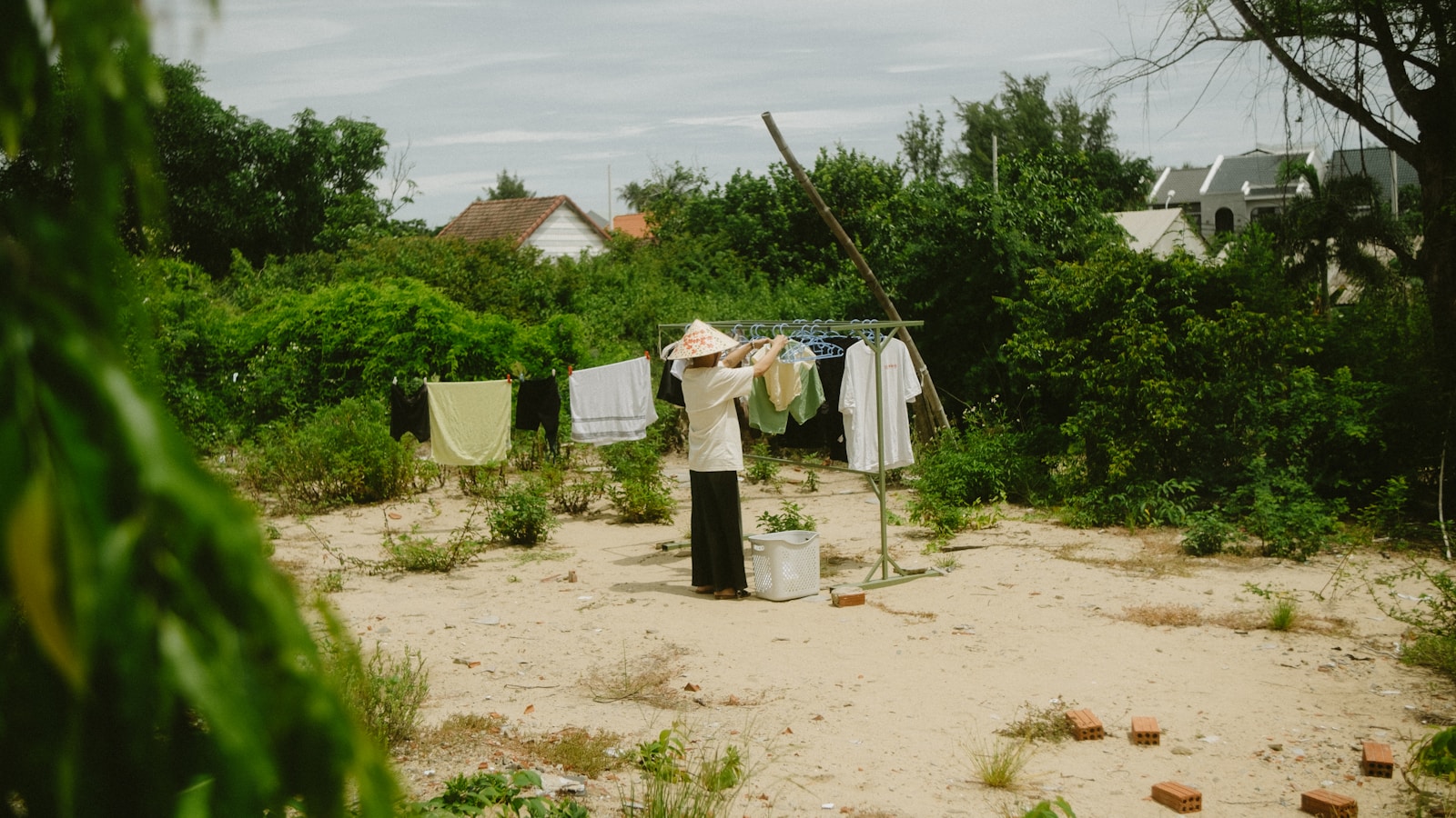 Person hanging laundry on a clothesline outdoors.