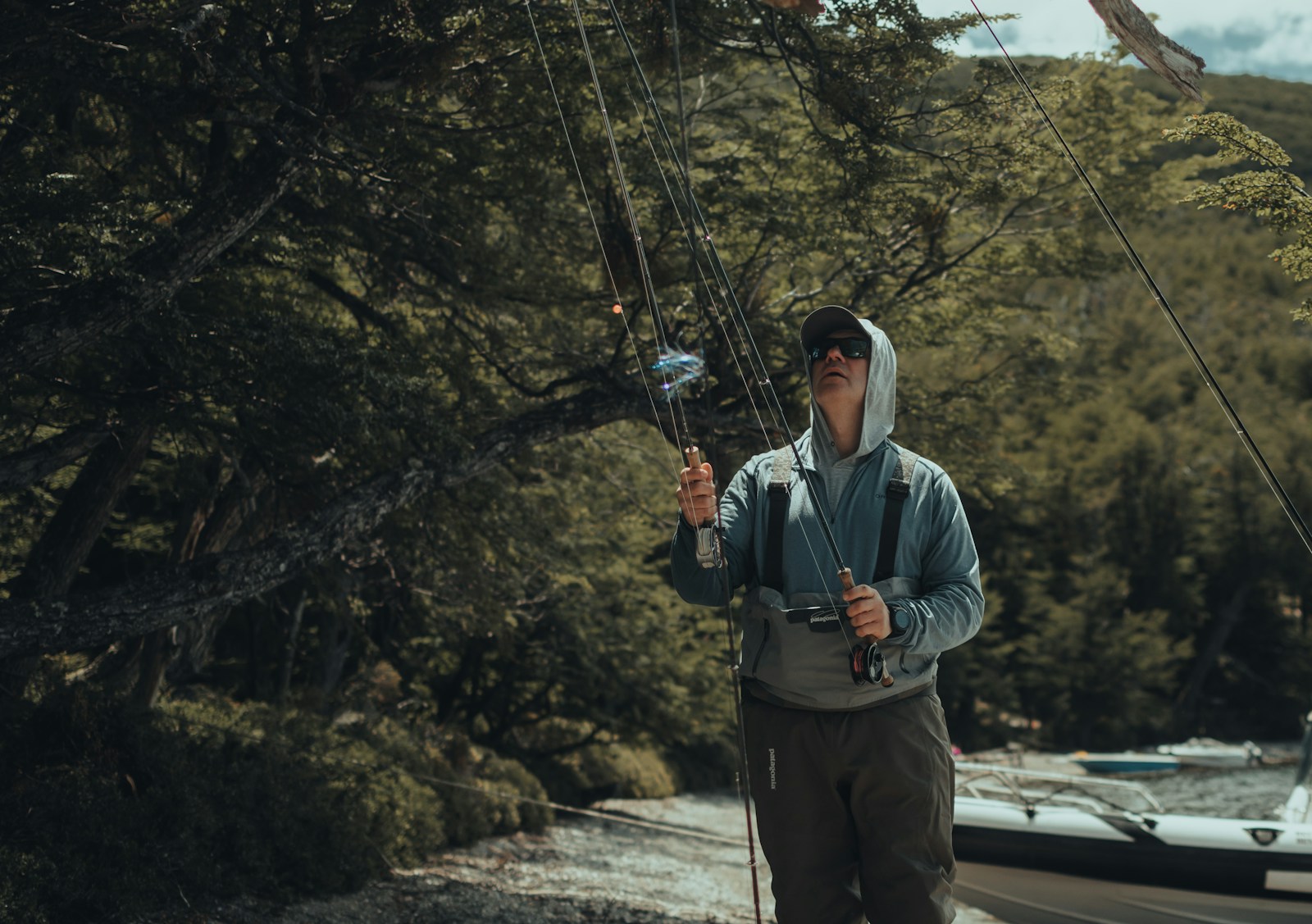 A man holding a fishing pole while standing on the side of a road