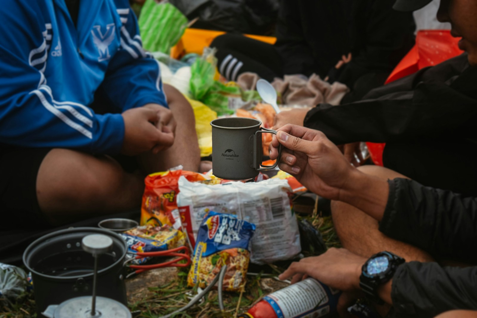 Campers Sitting on Ground and Eating Food