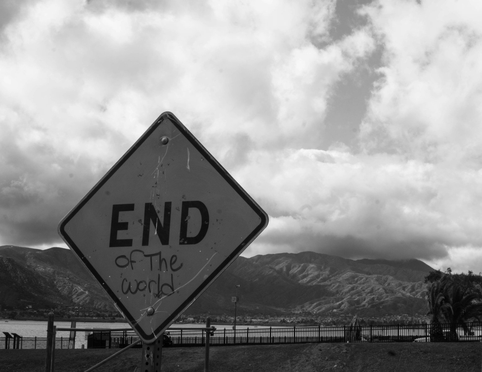 A black and white photo of a sign that says end of the road