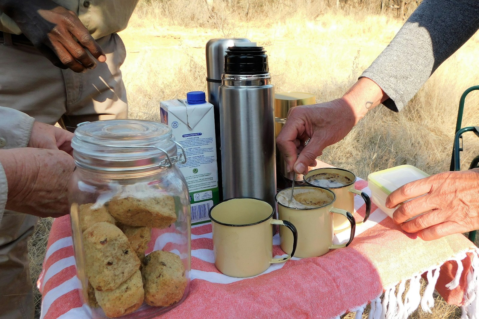a table topped with two mugs of coffee and cookies