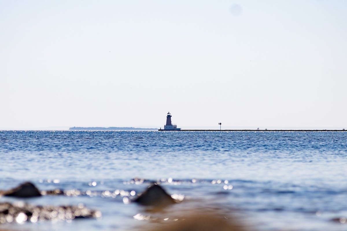 Blue Seascape with a Lighthouse on the Horizon