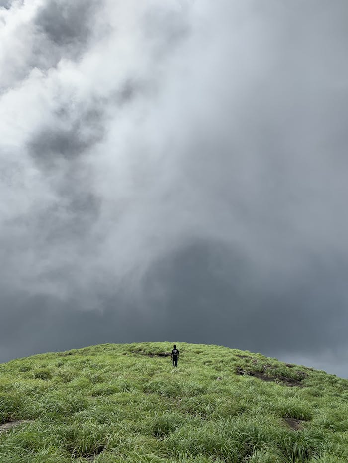 A Person Standing on a Cliff in Bad Weather