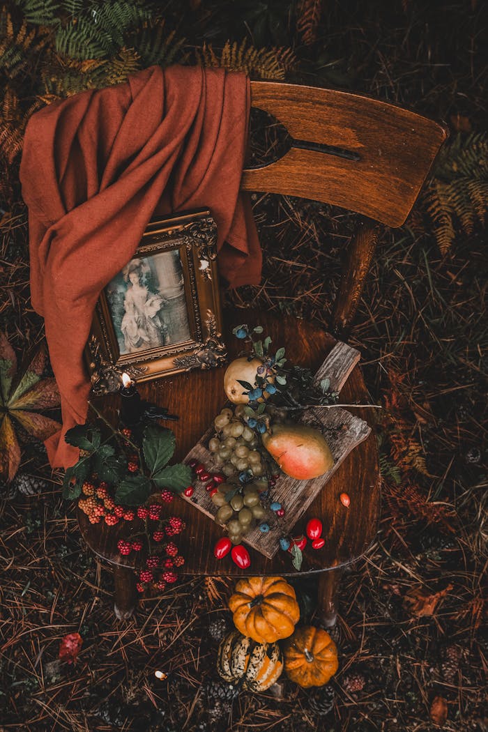 Decoration Made of Fruits and a Old Fashioned Picture on a Chair and Pumpkins Under It