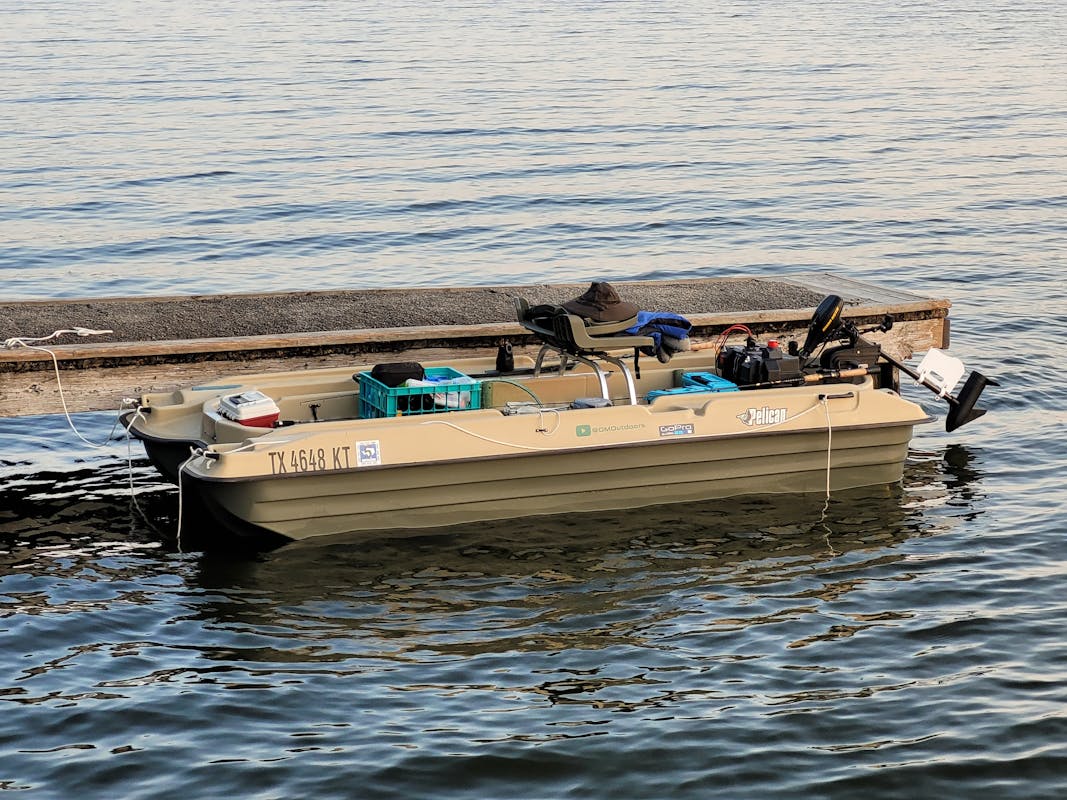 Small fishing boat in pond at boat dock in Texas