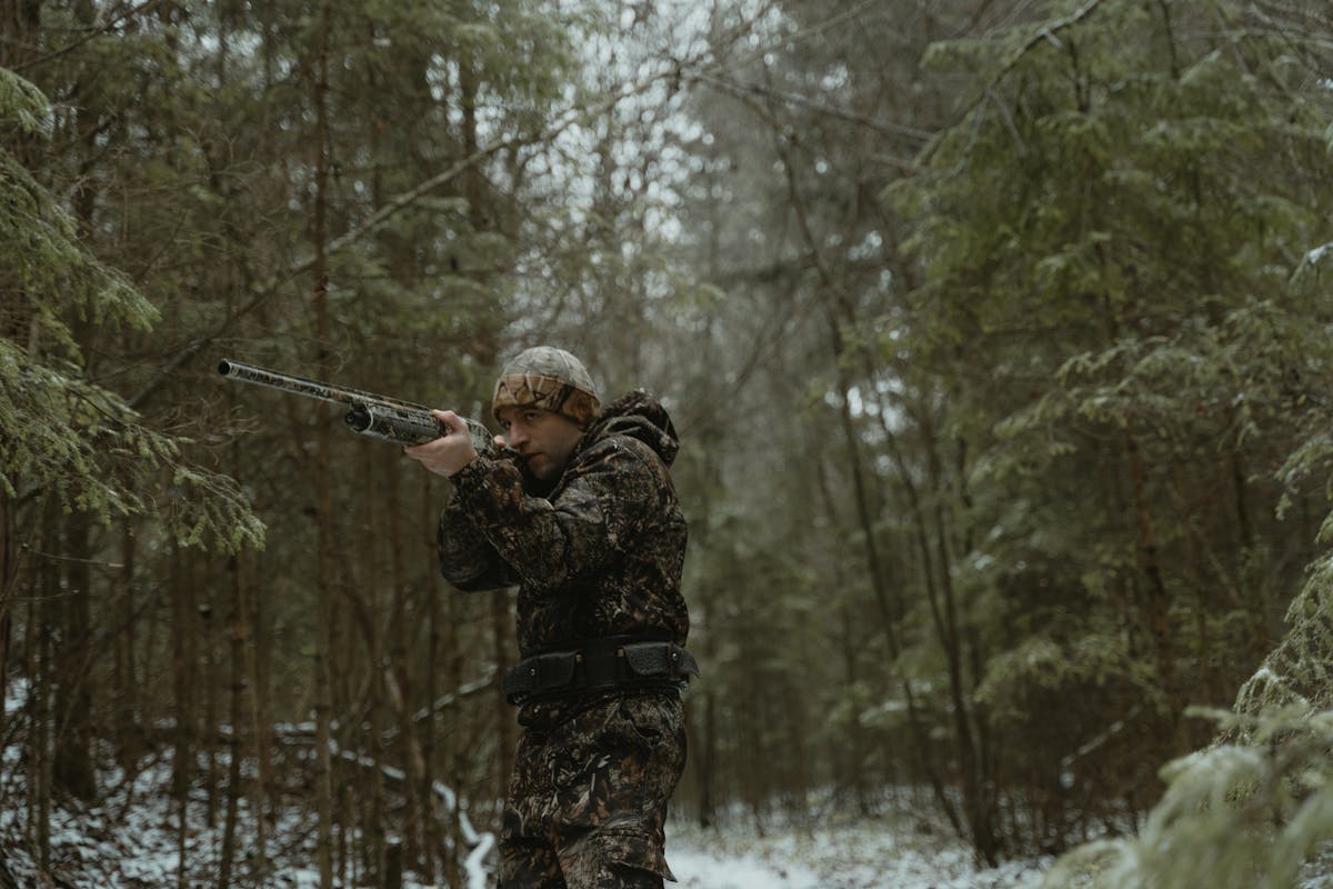 taiki-ishikawa-w6EMxsk8CDA-unsplash Man in Camouflage Jacket Holding Rifle