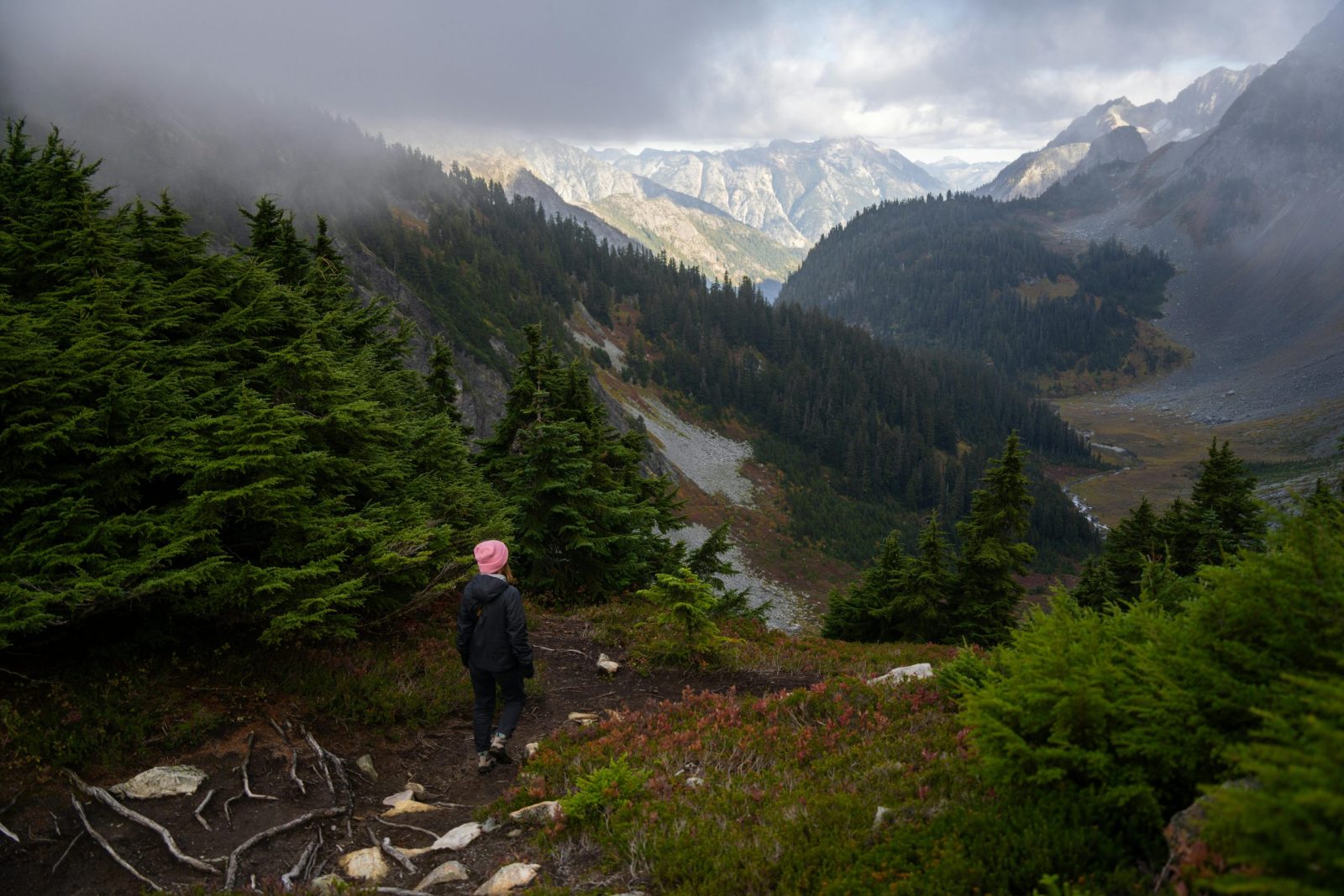 A woman hiking through the misty mountains of North Cascades National Park, Washington.
