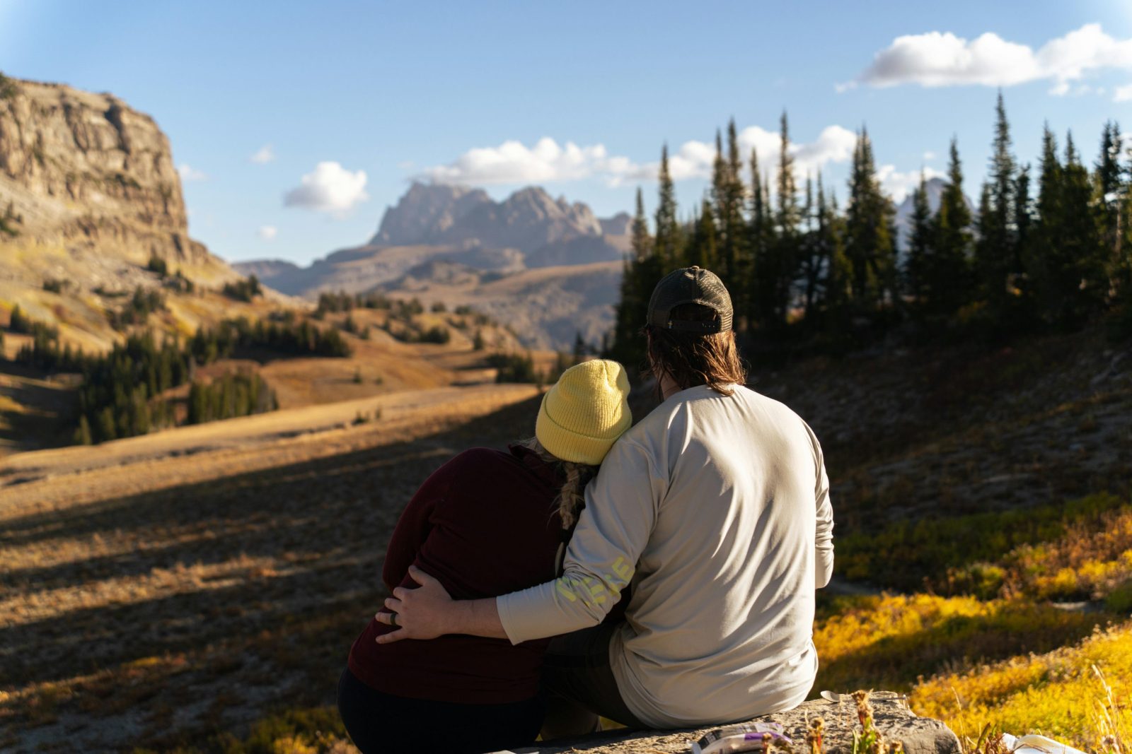 A couple embraces while enjoying a scenic mountain view at Grand Teton National Park, Wyoming.
