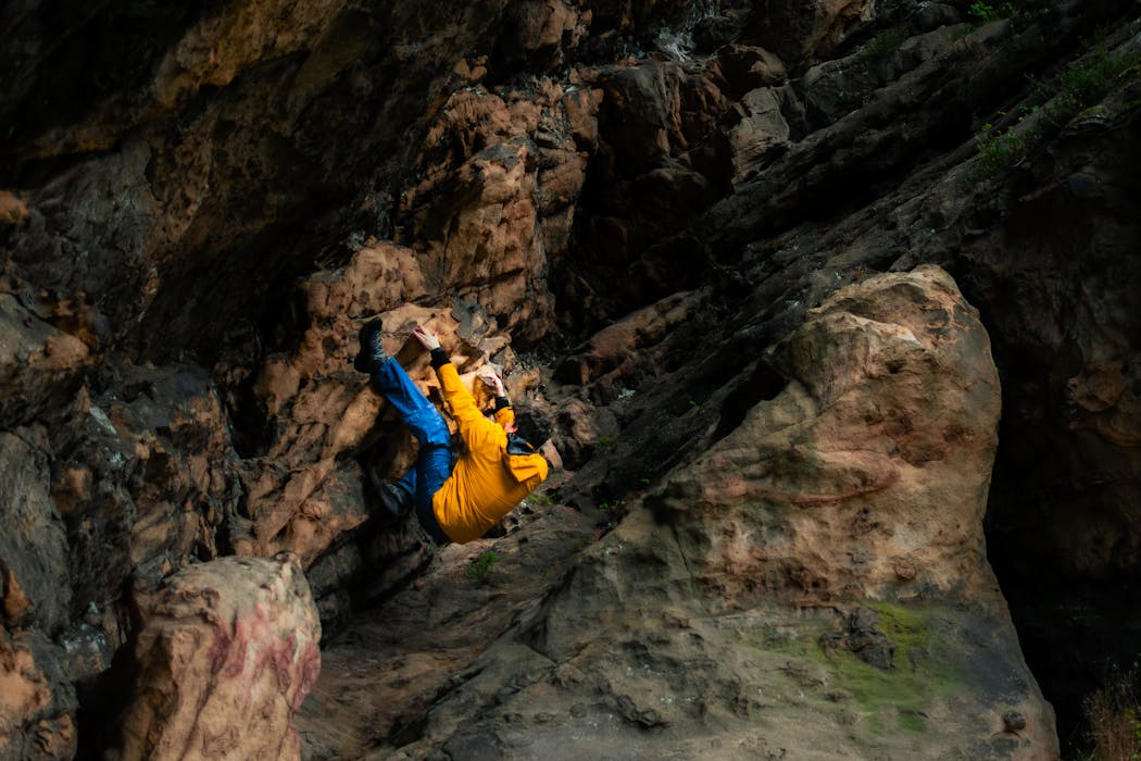 Man Climbing a Steep Rock Face