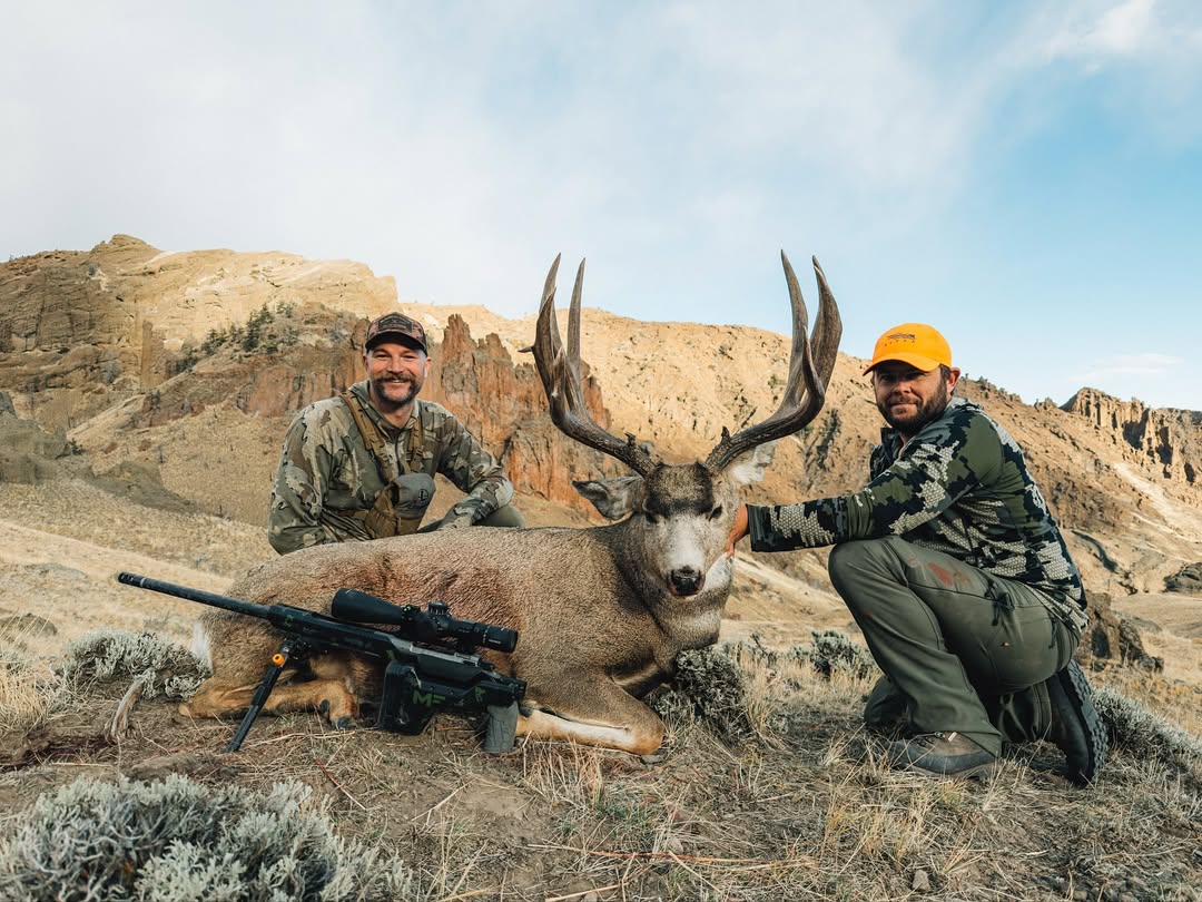Two Hunter Posing with an Elk and a Rifle