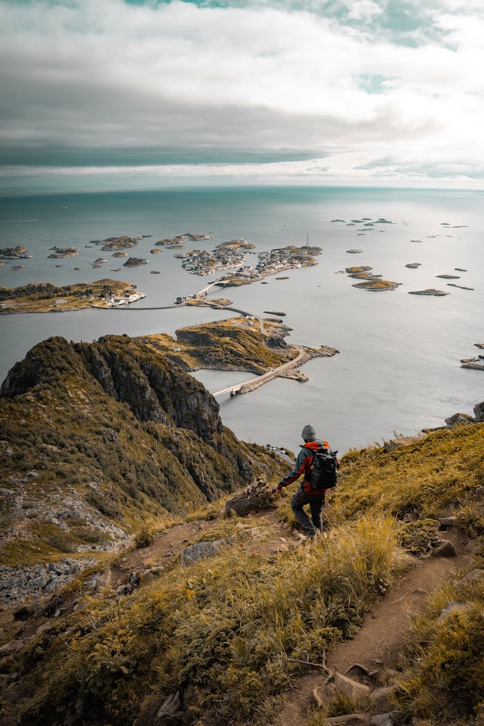 taiki-ishikawa-w6EMxsk8CDA-unsplash A person hiking up a mountain with the ocean in the background