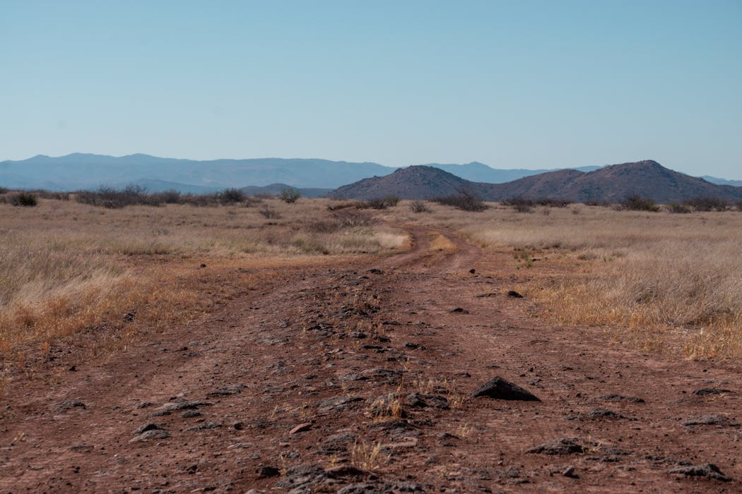 Rugged Desert Landscape with Dirt Road and Mountains