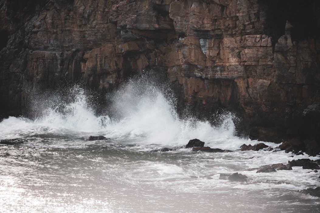 Dramatic Waves Crashing Against Rocky Cliffs Creating Roaring Sound