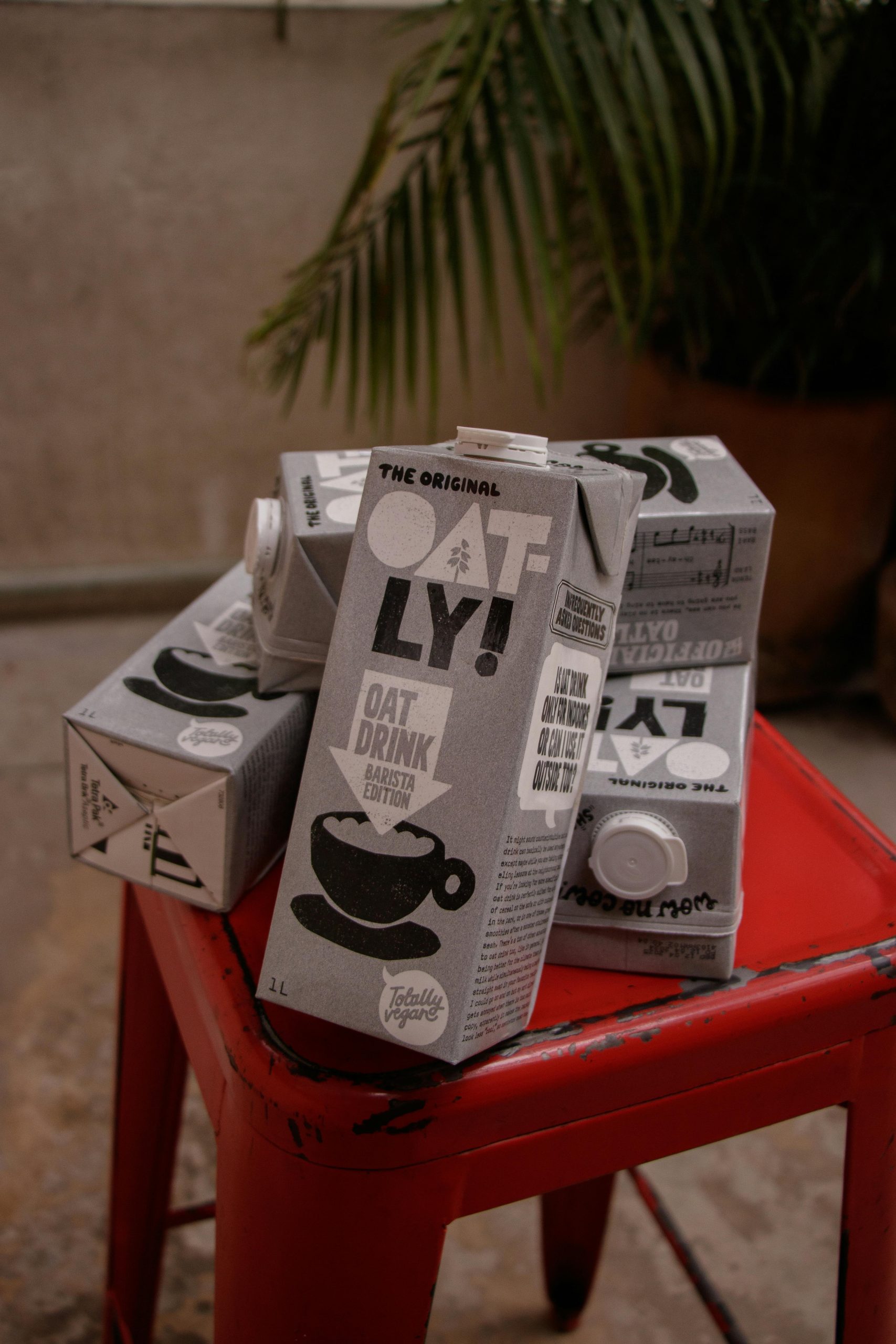 Oatly Oat Milk Cartons on Red Stool Indoors