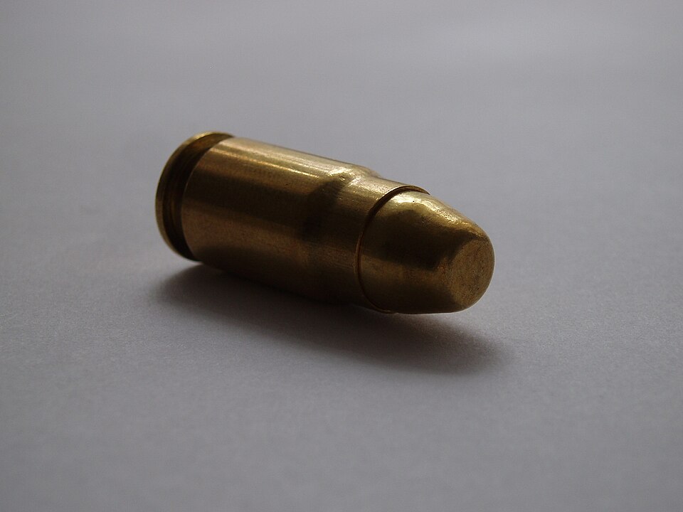 Oblique view of a .357 SIG FMJ cartridge.