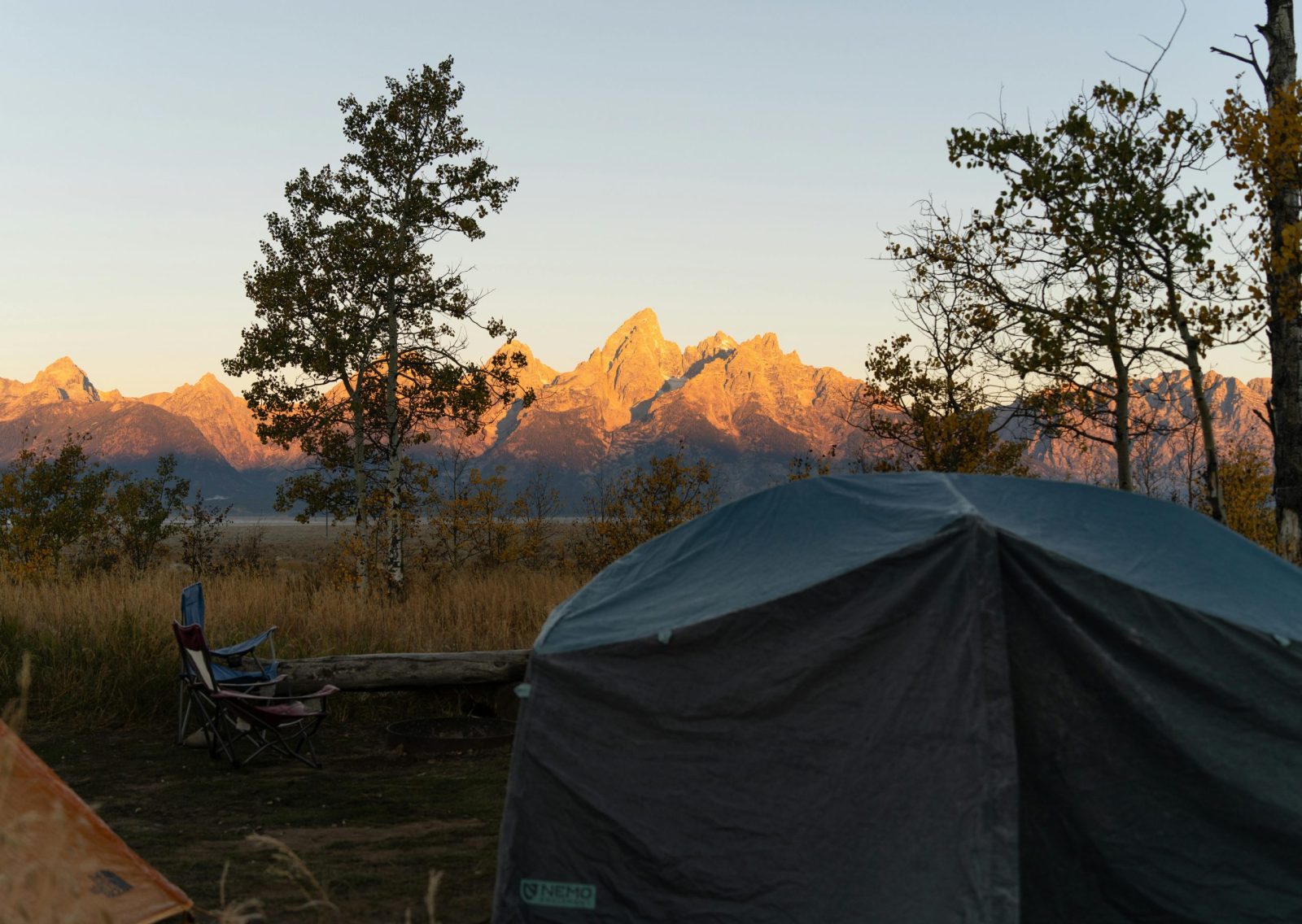 Experience autumn camping with a stunning view of the Grand Tetons in Wyoming.
