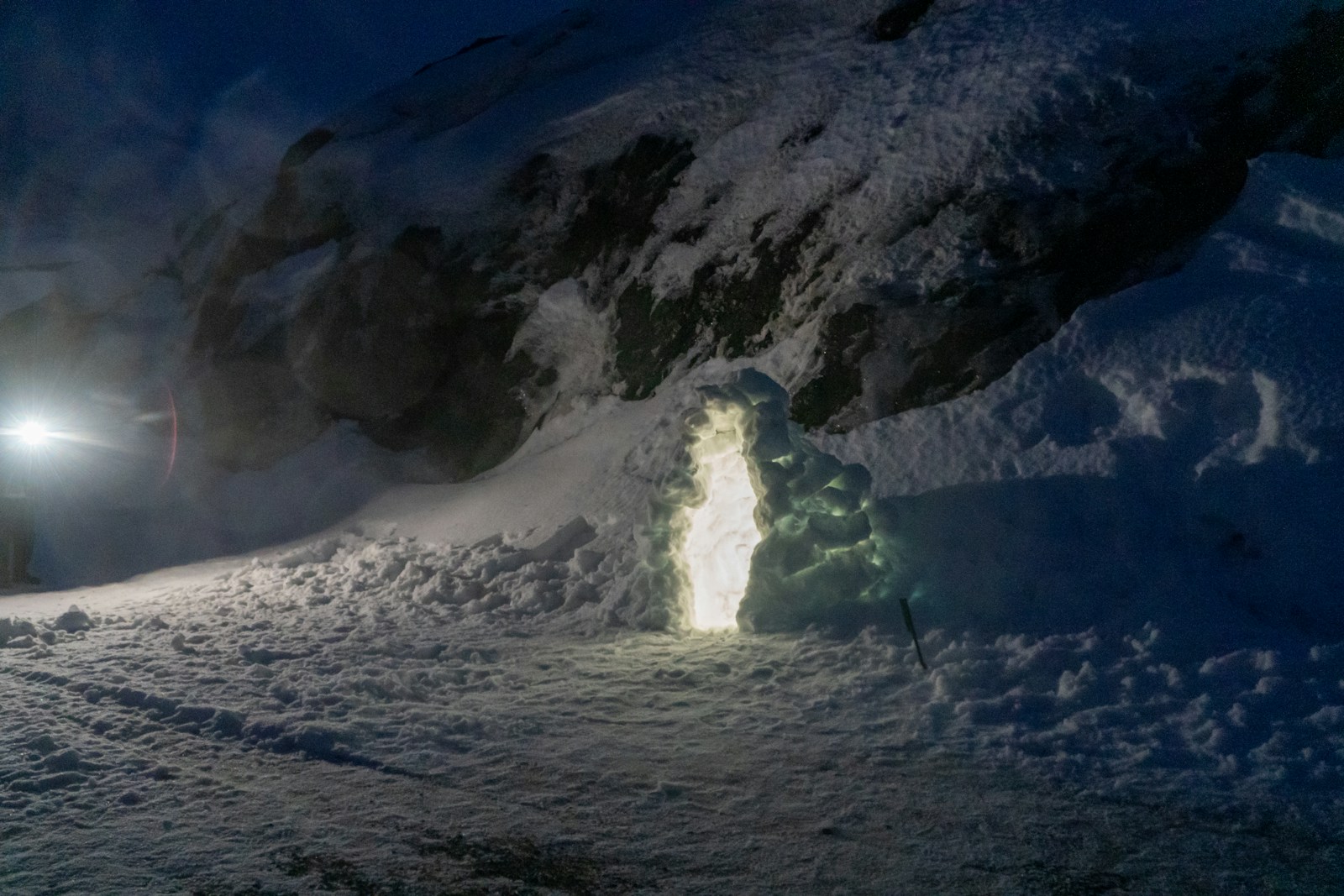 A person standing in the snow at night
