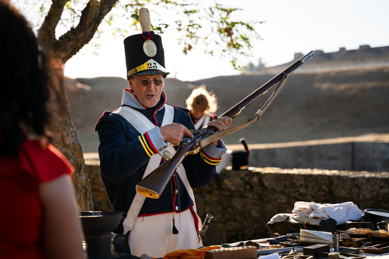Man in historical uniform holding a musket outdoors