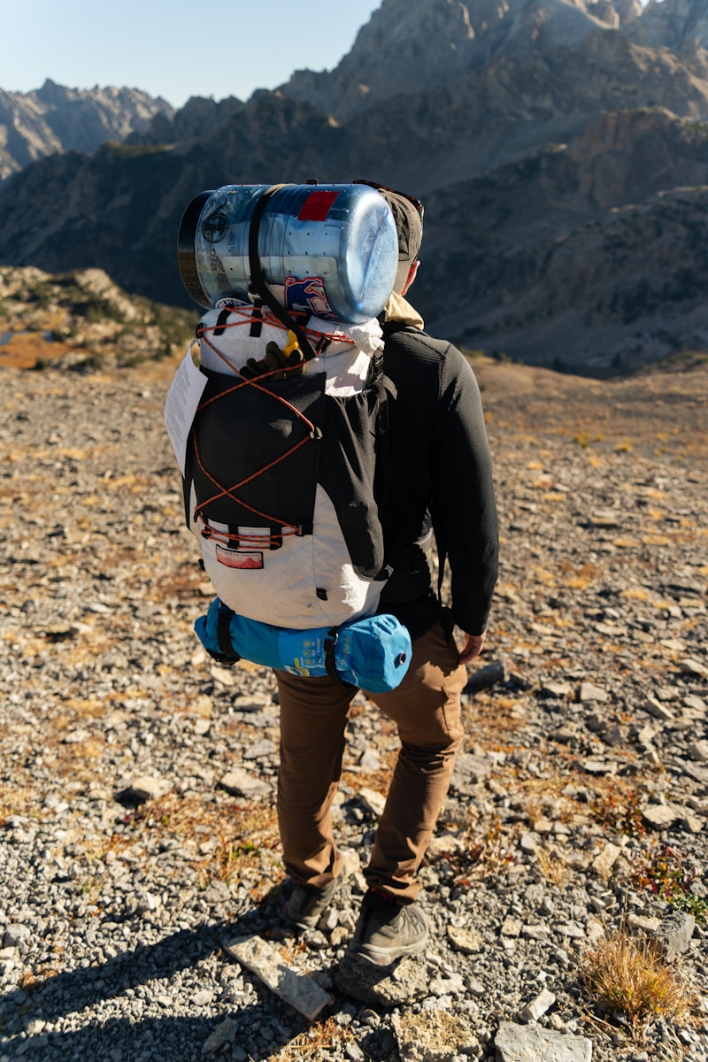 Hiker with large backpack in rocky mountain landscape