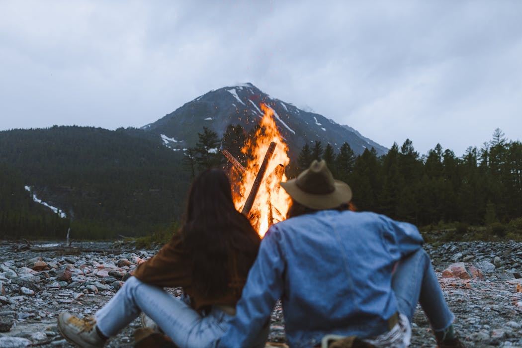 A Couple Starting a Bonfire in an Outdoor Adveture